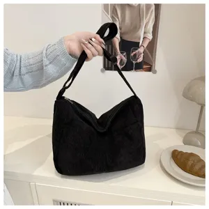 Dettaglio ravvicinato della borsa a tracolla in velluto nero con texture definita.