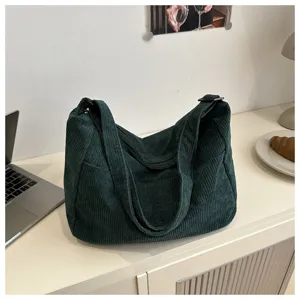 Primo piano della borsa a tracolla in velluto a coste verde scuro con dettagli della.