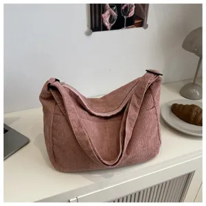 Dettaglio borsa a tracolla in velluto a coste, consistenza morbida, design casual per tutti i giorni.