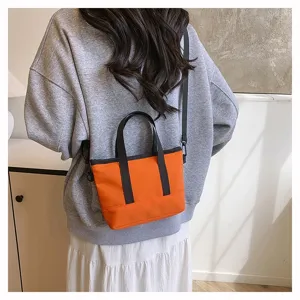 Detailed shot of a stylish orange small crossbody canvas bag worn casually on the back.