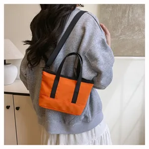 Detailed view of a casual orange crossbody bag worn on a model, showing texture and straps.