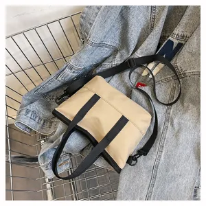 Minimalist solid color canvas crossbody bag with black webbing straps for daily casual use.