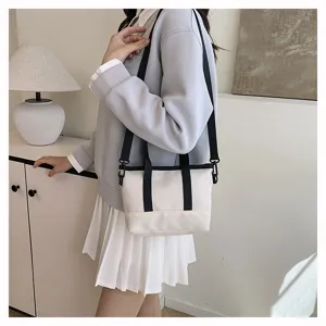 Close-up detail of casual canvas crossbody bag worn by model, showing strap and style.