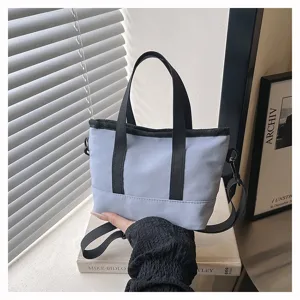 Detail view of mini casual canvas crossbody bag, light blue with black straps, daily wear.