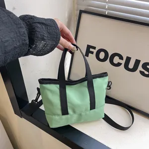Casual green canvas crossbody bag for women, small shoulder tote with black handles.