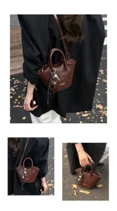 Detailansicht der retro dunkelbraunen Damen Umhängetasche mit stilvollem Anhänger und Griffen.