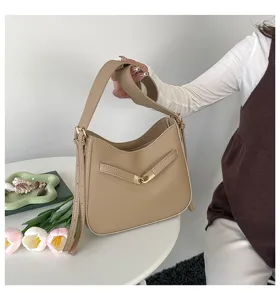 Close-up detail of a chic khaki shoulder bag featuring elegant metal lock and adjustable strap.