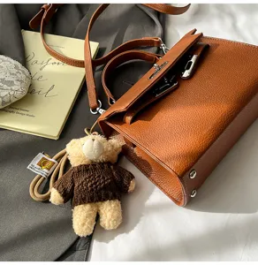 Bolso de hombro marrón estilo Kelly retro con bonito colgante de oso de punto, elegante y chic.
