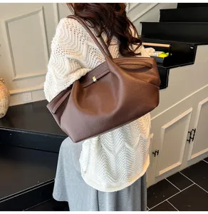 Vista dettagliata della borsa a spalla in pelle marrone, design morbido con chiusura.