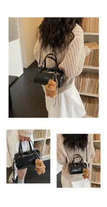 Vintage black oil wax leather pillow bag with cute plush bear pendant, stylish women's shoulder bag.