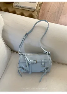 Light blue cylindrical shoulder bag with stylish tassels and metal hardware details.