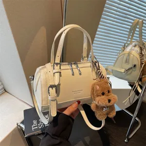 Chic PU leather boston handbag for women, stylish top handle shoulder crossbody bag with cute charm.