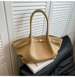 Dettaglio di una borsa tote casual in pelle beige con doppi manici e chiusura metallica.