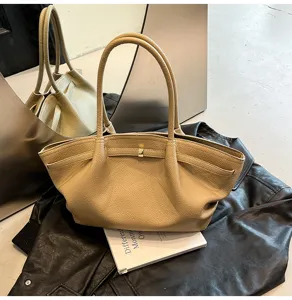 Vista dettagliata di una elegante borsa tote in pelle beige, ideale per lavoro e tempo libero.