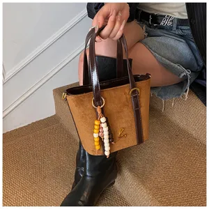 Retro brown suede bucket bag for women, stylish PU patchwork handbag with beaded charm.