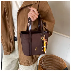 Stylish retro PU suede bucket bag with top handle and chic beaded charm, autumn winter.