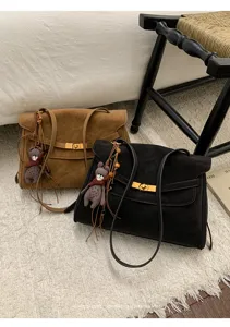 Detailansicht der Retro Wildleder Umhängetasche mit süßem Bärenanhänger und Metallverschluss.