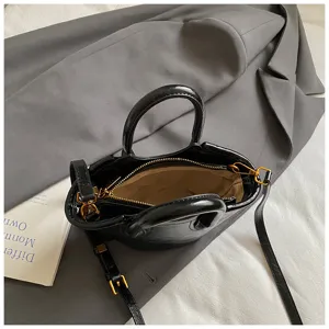 Schwarze Lackleder Mini Handtasche mit Griffen und Schultergurt, stilvolle Detailansicht.