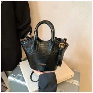 Schicke Vintage schwarze Handtasche mit glänzender Oberfläche, strukturiertem Design und Schultergurt.
