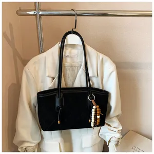 Dettaglio borsa shopper trapuntata in camoscio nero, elegante borsa da lavoro con perline.