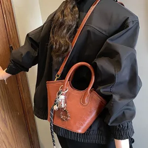 Braune Retro Leder Handtasche für Damen, stilvolle Umhängetasche mit Henkel und Anhänger.