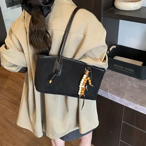 Borsa a tracolla trapuntata in camoscio nero con ciondolo di perline per donna chic.