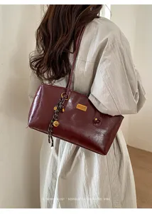 Vista detallada del elegante bolso retro rojo angora bajo el brazo llevado al hombro.