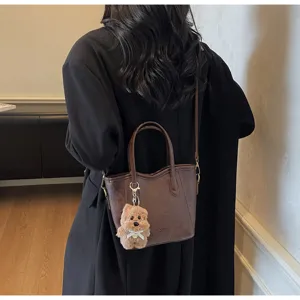 Classic retro bucket bag with cute plush pendant, stylish shoulder handbag for daily wear.