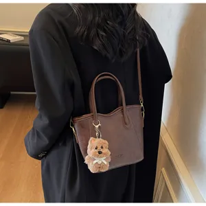 Retro brown bucket bag with plush bear charm, stylish casual shoulder and crossbody bag for women.