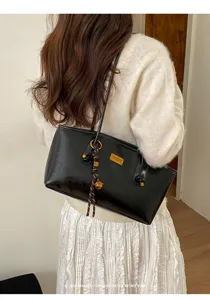 Bolso de hombro minimalista negro en cuero para mujer, bolso versátil para uso diario.