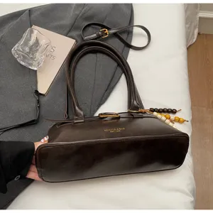 Vintage dark brown leather shoulder bag for women, elegant retro underarm handbag with chic strap.