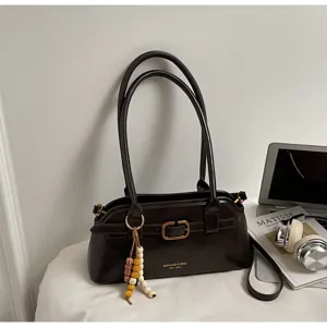 Retro brown leather shoulder bag detail, elegant underarm bag with metal buckle and strap.