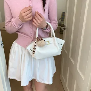Chic white leather handbag with metal buckle and cute plush charm for women daily fashion style.