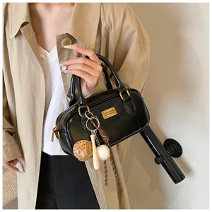 Fashion black patent leather Boston handbag with cute baseball keychains and metal plaque.