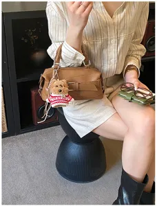 Trendy brown Boston shoulder bag for women, stylish bowling handbag with cute dog pendant.