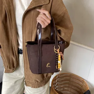 Vintage brown suede bucket bag for women, stylish PU patchwork handbag with charms.