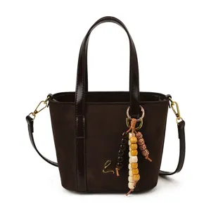 Brown suede bucket bag for women, stylish PU leather patchwork handbag with wooden bead charm.