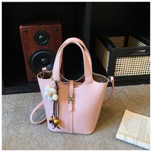 Rosa Eimer Tasche für Damen, stilvolle Handtasche mit Schultergurt und Blumenanhänger.