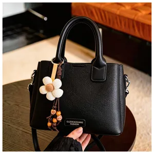 Black leather shoulder bag detail, elegant floral charm design, stylish women daily accessory.