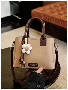 Khaki brown PU leather shoulder bag with chic flower charm and top handle, detail view.