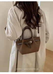 Detailansicht der retro braunen Ledertasche mit Gürtelschnallen-Dekoration und feiner Naht.