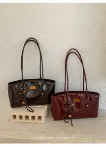 Vista detallada del bolso de hombro vintage bajo el brazo con gran capacidad y estilo retro.