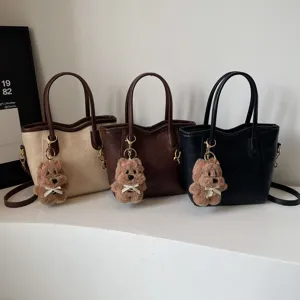 Retro PU leather bucket handbag with cute fluffy bear pendant, stylish shoulder crossbody bag.