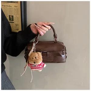 Brown leather bowling handbag, vintage Boston shoulder bag with cute fluffy bear keychain.