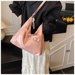 Pink patent leather hobo shoulder bag with pearl pendant, stylish commuter daily tote.
