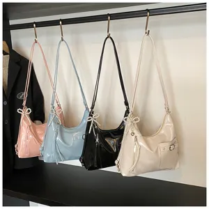 Close-up detail view of multi-color soft leather tote bags hanging with elegant pearl bow charms.