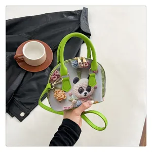 Vue détaillée du joli sac à main crocheté de panda mignon avec poignée verte et broderie.