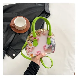 Vue détaillée du sac à bandoulière imprimé dessin animé rétro avec motif floral au crochet.