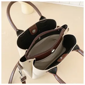 Detailed view of the multi-compartment interior, zipper pocket, and contrast brown trim.