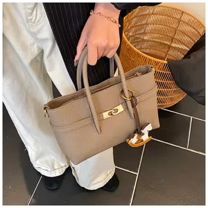 Detail view of a stylish grey leather tote shoulder bag with metal lock and cute horse charm.